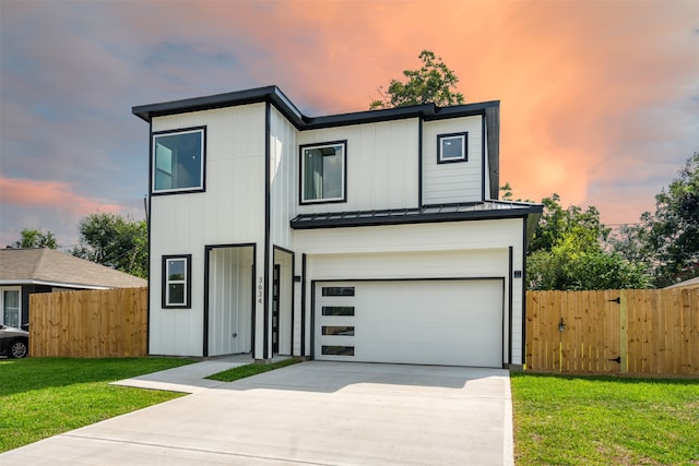 modern home featuring a garage and a yard