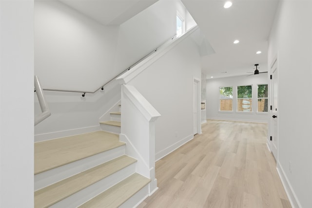 stairway featuring ceiling fan and hardwood / wood-style floors