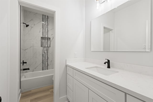 bathroom featuring hardwood / wood-style floors, tiled shower / bath, and vanity