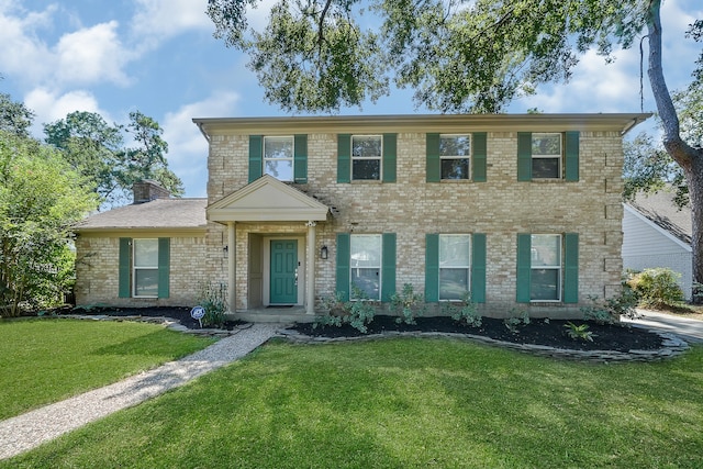 colonial-style house featuring a front yard