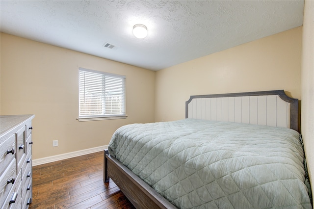 bedroom featuring a textured ceiling and dark wood-type flooring