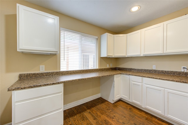 kitchen featuring built in desk, white cabinetry, and dark hardwood / wood-style flooring