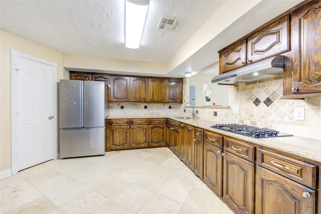 kitchen with decorative backsplash, stainless steel appliances, a textured ceiling, and sink