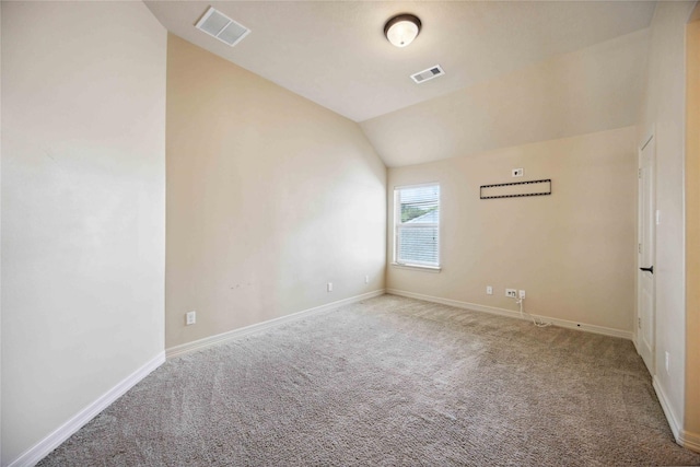 carpeted empty room with lofted ceiling