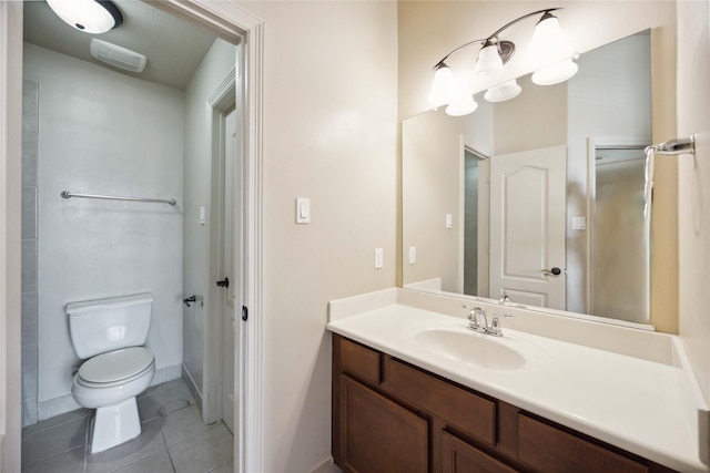 bathroom with toilet, vanity, and tile patterned floors