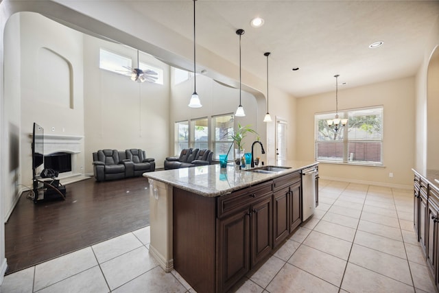 kitchen featuring light stone counters, sink, pendant lighting, and light tile patterned floors