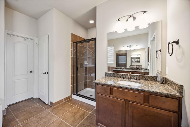 bathroom with tile patterned flooring, a shower with shower door, and vanity