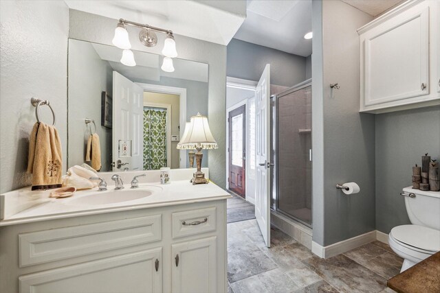 bathroom with an enclosed shower, vanity, and toilet