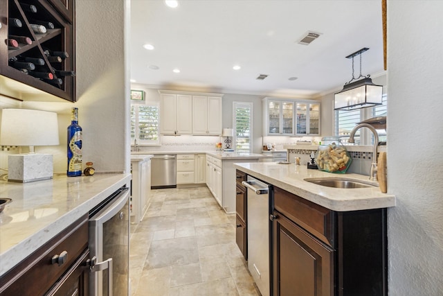 kitchen with dark brown cabinets, wine cooler, sink, and a wealth of natural light