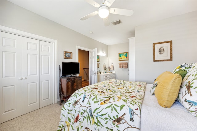 bedroom featuring a closet, light colored carpet, and ceiling fan