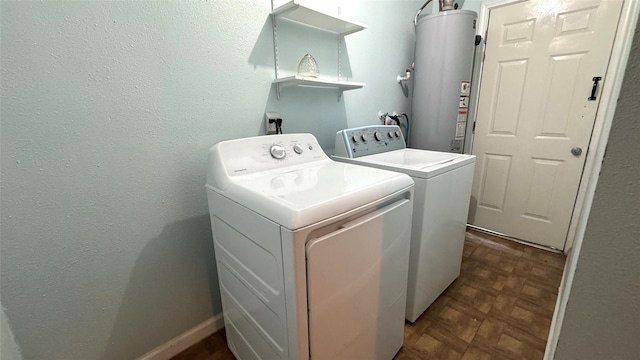 washroom featuring water heater, dark parquet floors, and washing machine and clothes dryer