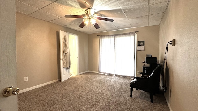 living area featuring a paneled ceiling, carpet flooring, and ceiling fan