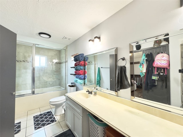 full bathroom featuring vanity, enclosed tub / shower combo, a textured ceiling, toilet, and tile patterned floors