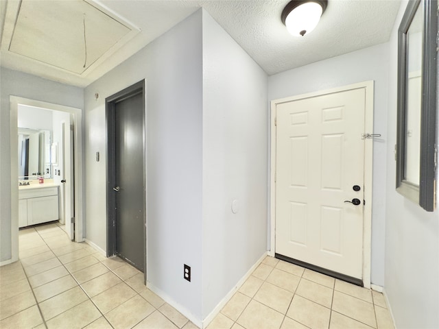 foyer entrance with a textured ceiling and light tile patterned floors