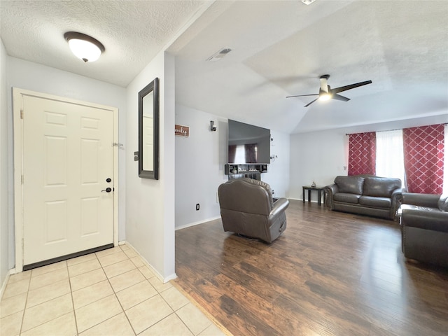 foyer with light wood-type flooring, a textured ceiling, and ceiling fan