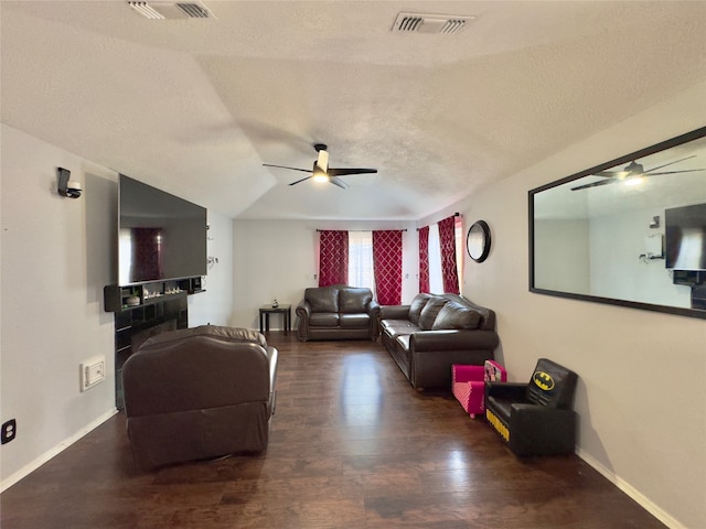 living room featuring ceiling fan, a textured ceiling, lofted ceiling, and dark wood-type flooring