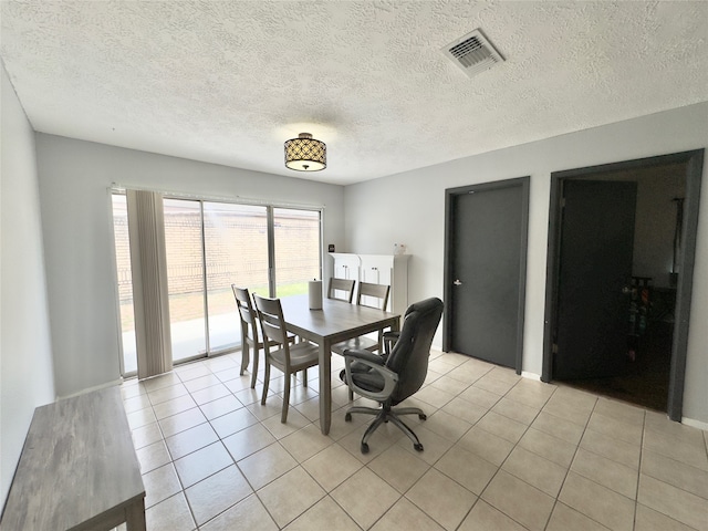 tiled dining area with a textured ceiling