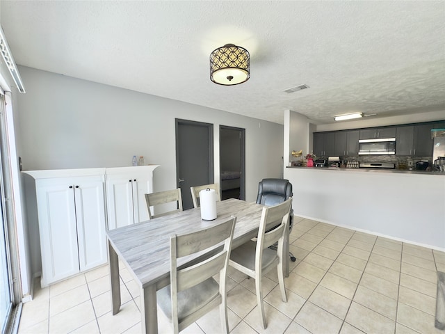 tiled dining area featuring a textured ceiling