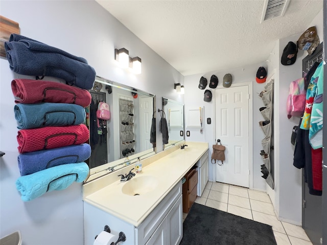 bathroom with a textured ceiling, tile patterned flooring, and vanity