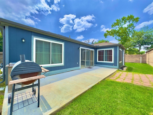 back of property featuring a lawn and a patio area