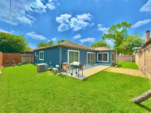 back of house with a lawn, a patio, and central AC