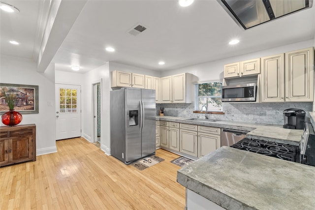 kitchen with light hardwood / wood-style floors, sink, stainless steel appliances, and a wealth of natural light