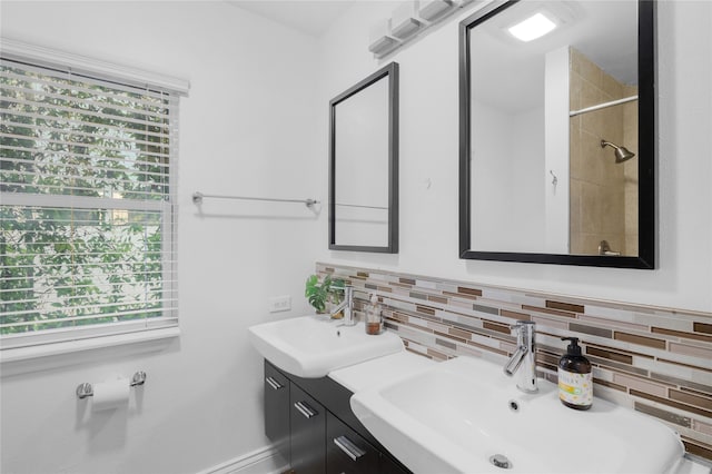 bathroom with vanity, tasteful backsplash, and a healthy amount of sunlight