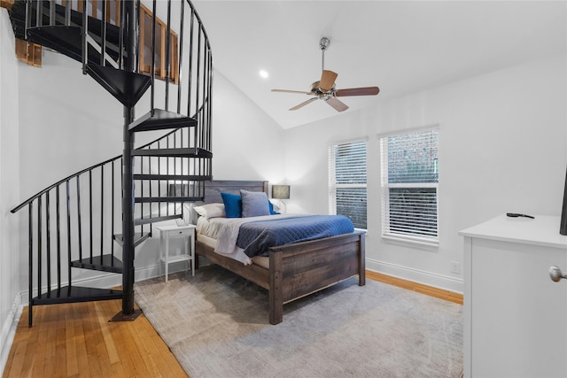 bedroom featuring hardwood / wood-style floors, vaulted ceiling, and ceiling fan