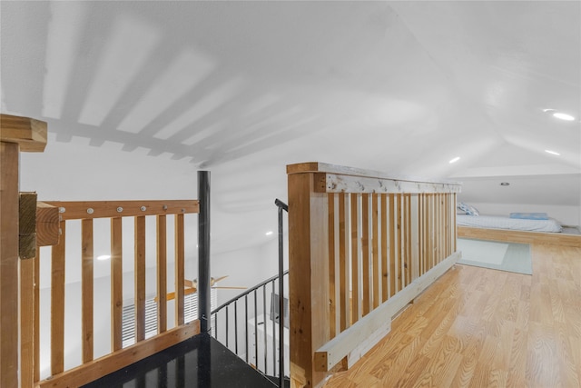 hall with lofted ceiling and light wood-type flooring