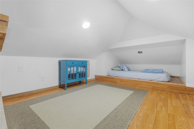 bedroom featuring wood-type flooring and vaulted ceiling