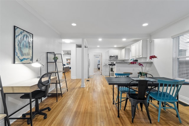 dining room with crown molding and light wood-type flooring