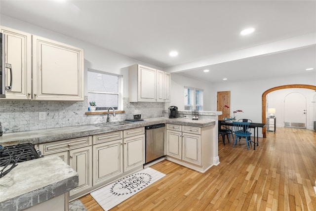 kitchen with kitchen peninsula, backsplash, sink, light hardwood / wood-style flooring, and dishwasher