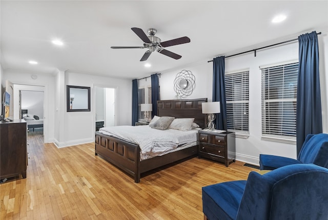 bedroom featuring ensuite bath, ceiling fan, and light hardwood / wood-style floors