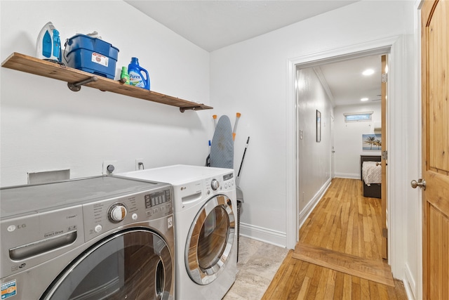 laundry room featuring light wood-type flooring and washing machine and clothes dryer