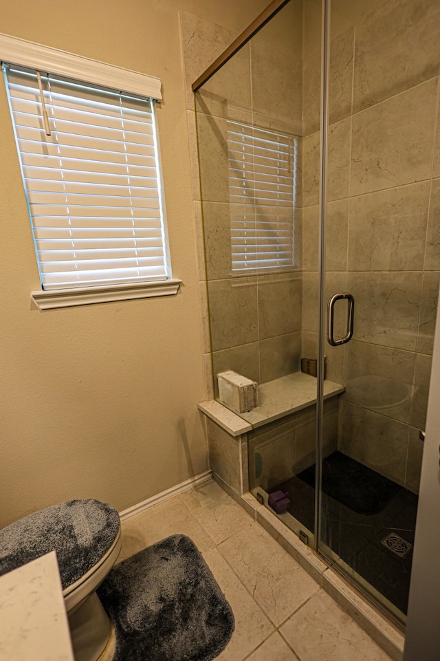 bathroom featuring tile patterned flooring, toilet, and an enclosed shower