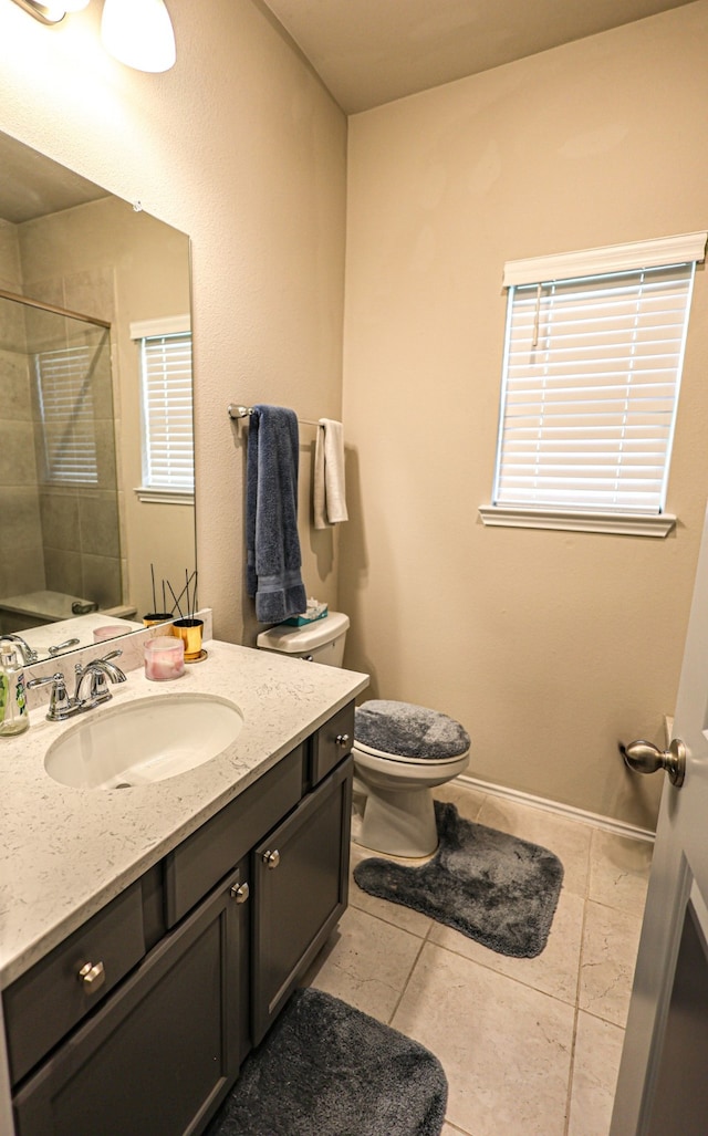 bathroom featuring tile patterned floors, tiled shower, vanity, and toilet