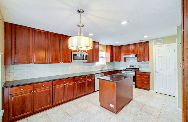 kitchen featuring a kitchen island, pendant lighting, stainless steel appliances, sink, and a chandelier