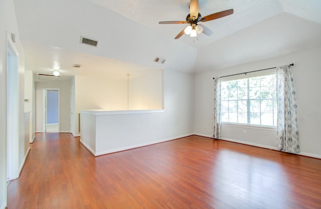 spare room featuring a textured ceiling, vaulted ceiling, dark hardwood / wood-style floors, and ceiling fan