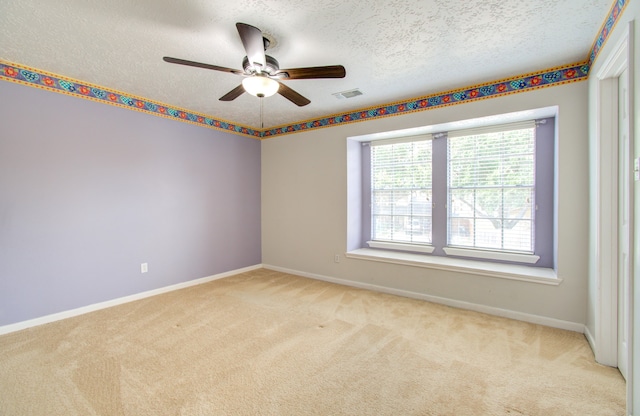 carpeted empty room with ceiling fan, a textured ceiling, and plenty of natural light