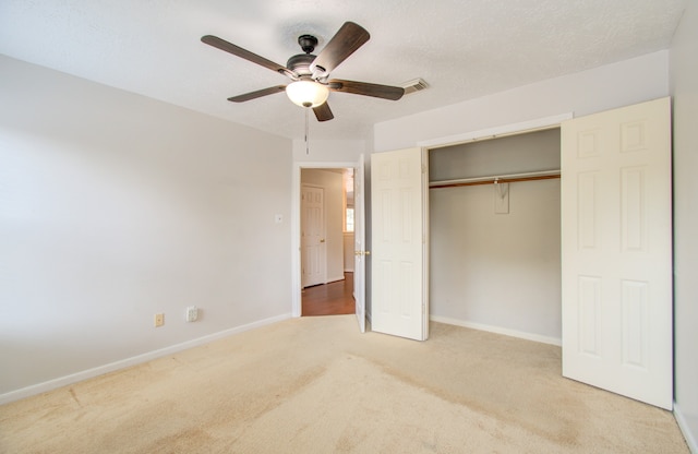 unfurnished bedroom featuring ceiling fan, a textured ceiling, a closet, and carpet flooring