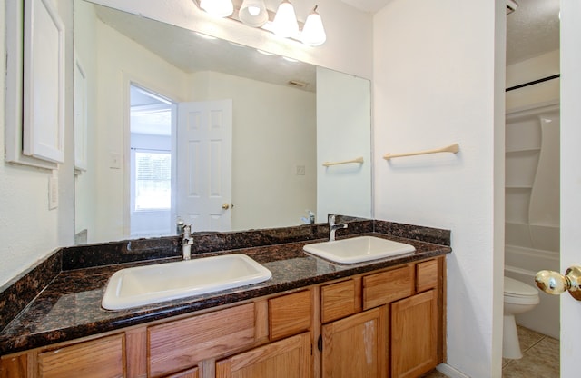 bathroom featuring tile patterned floors, a washtub, vanity, and toilet