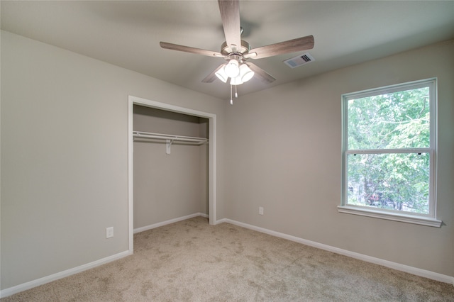 unfurnished bedroom with a closet, ceiling fan, and light colored carpet