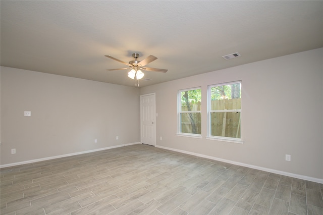 unfurnished room featuring light hardwood / wood-style flooring, ceiling fan, and a textured ceiling