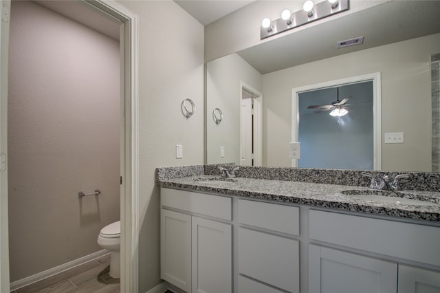 bathroom featuring ceiling fan, hardwood / wood-style flooring, vanity, and toilet