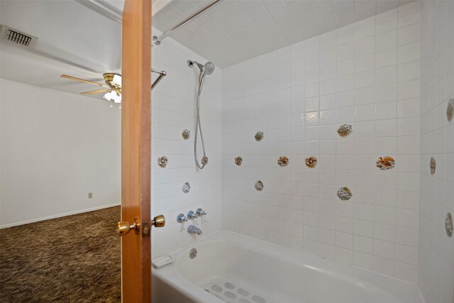 bathroom featuring ceiling fan and tiled shower / bath