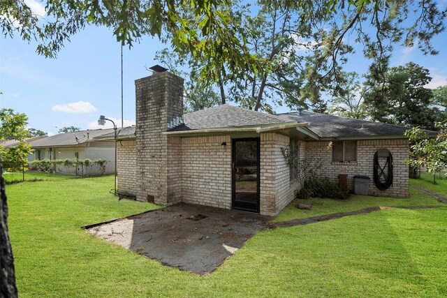 back of property with a yard and a patio area