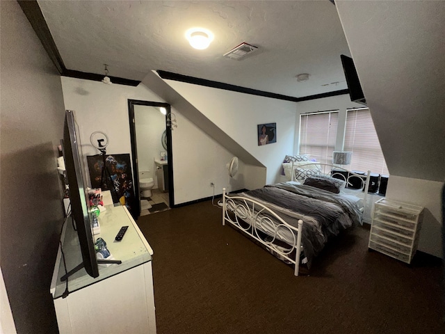 bedroom featuring ensuite bathroom, ornamental molding, and a textured ceiling