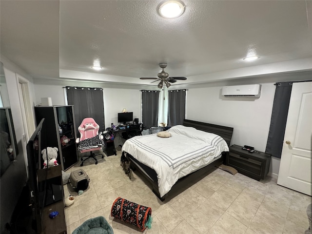 bedroom featuring ceiling fan, a textured ceiling, and a wall unit AC