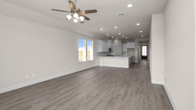 unfurnished living room with ceiling fan and light hardwood / wood-style flooring