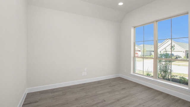 empty room featuring hardwood / wood-style floors and lofted ceiling